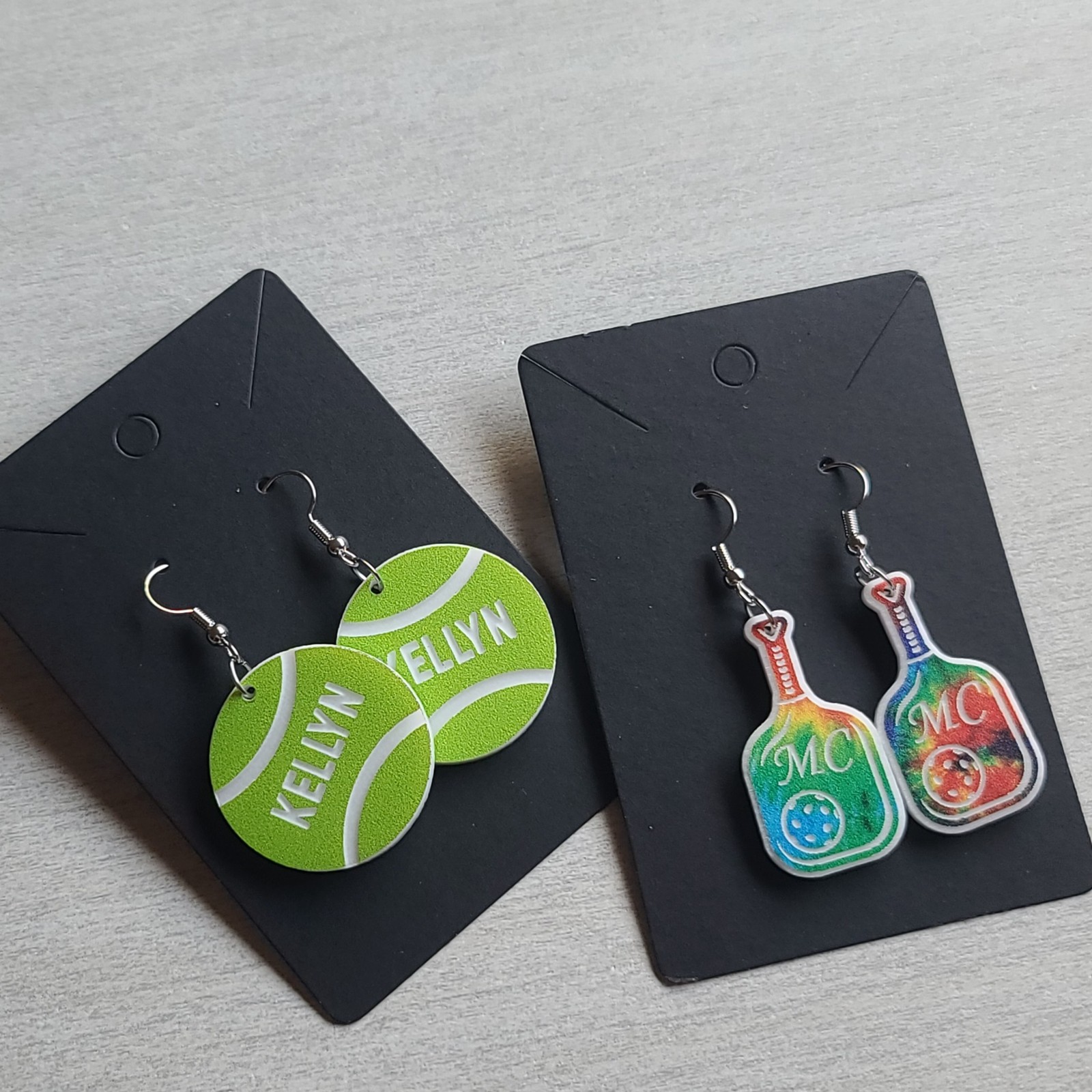 Tennis and basketball earrings on black display cards
